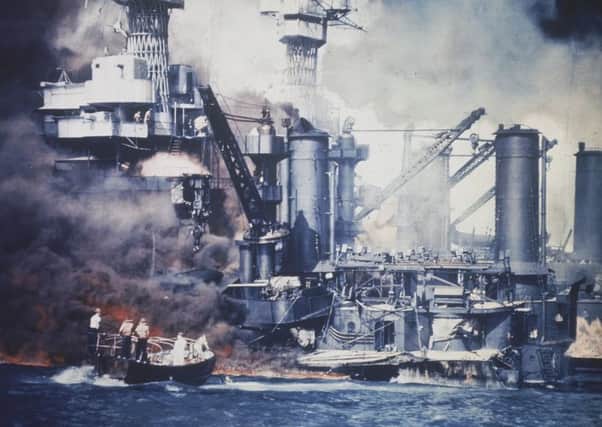 A small boat rescues a USS West Virginia crew member from the water after the Japanese bombing of Pearl Harbor. Picture: AP