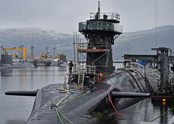 Royal Navy security personnel stand guard on HMS Vigilant at Clyde naval base. (Photo by Jeff J Mitchell/Getty Images)