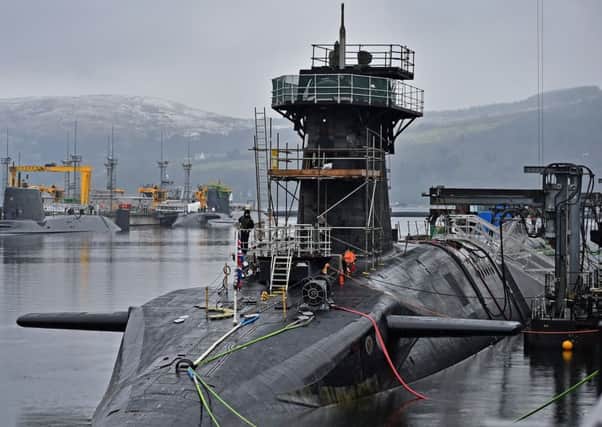 Royal Navy security personnel stand guard on HMS Vigilant at  Clyde naval base. (Photo by Jeff J Mitchell/Getty Images)
