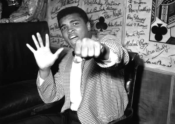 Muhammad Ali, then known as Cassius Clay, holds up five fingers in a prediction of how many rounds it will take him to knock out Henry Cooper in 1963. Picture: Kent Gavin/Keystone/Getty Images