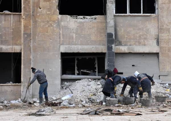 Syrian workers remove rubble as they clean up the water station in Aleppos Suleiman al-Halabi neighbourhood. Picture: AFP/Getty Images