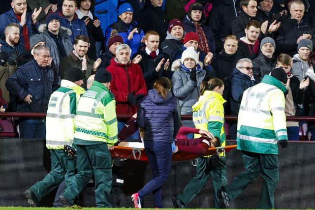 Hearts' Callum Paterson holds his shirt over his face as he is carried off after sustaining a serious knee injury against Kilmarnock. Picture: Roddy Scott/SNS