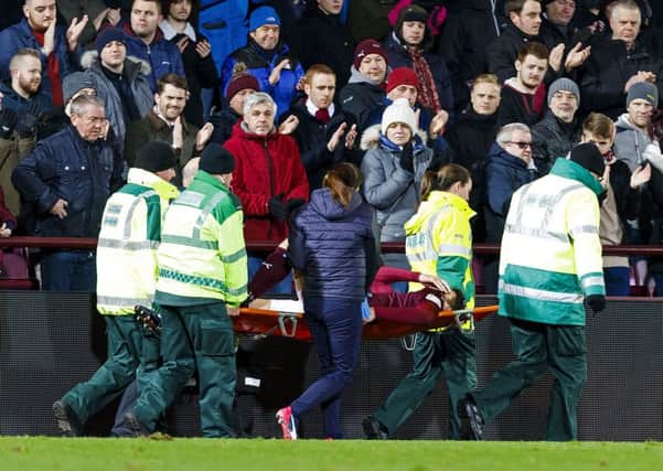 Hearts' Callum Paterson holds his shirt over his face as he is carried off after sustaining a serious knee injury against Kilmarnock. Picture: Roddy Scott/SNS