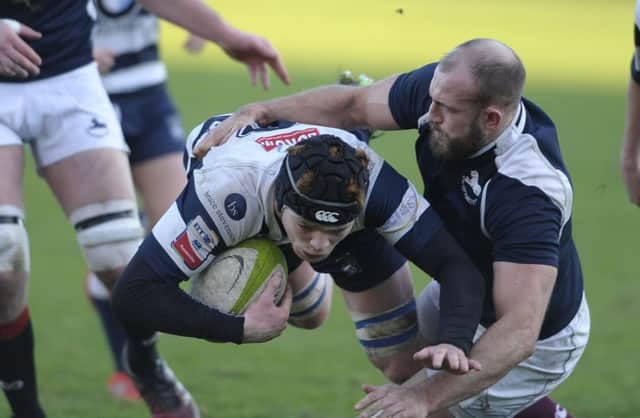 Martin Hughes of Heriot's is tackled by Rory Drummond of the Co-Optimists at 
Goldenacre. 
Picture: Neil Hanna