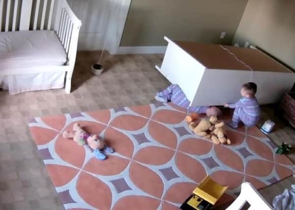 The young boy lifts the furniture to free his brother. Picture: Kaylee Shoff/Youtube