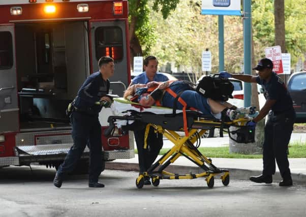 An injured woman is taken into Broward Health Trauma Center after a shooting at Fort Lauderdale airport. Picture: AP