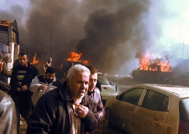 Residents flee from burning cars and debris shortly after the explosion. Picture: AFP/Getty Images