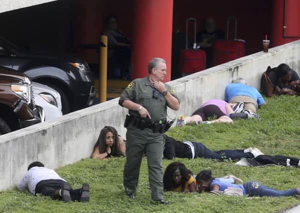 People take cover after the Fort Lauderdale shooting spree by Esteban Santiago. Picture: AP