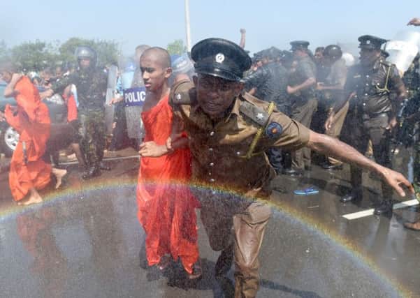 A Sri Lankan police officer pulls a monk away from a protest in the port city of Hambantota. Picture: AFP/Getty Images