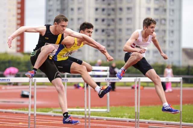 Carnousties Joel MacFarlane, left, competes in the hurdles.