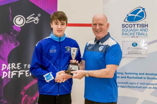Alasdair Prott is presented with his Under-17 winners trophy by Scottish Squash and Racketball president Jim Hay.