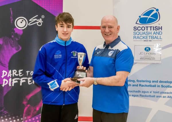 Alasdair Prott is presented with his Under-17 winners trophy by Scottish Squash and Racketball president Jim Hay.