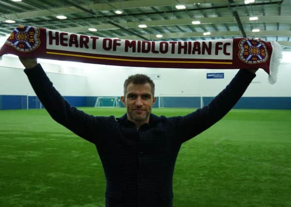 Northern Ireland defender Aaron Hughes has signed for Hearts until the end of the season