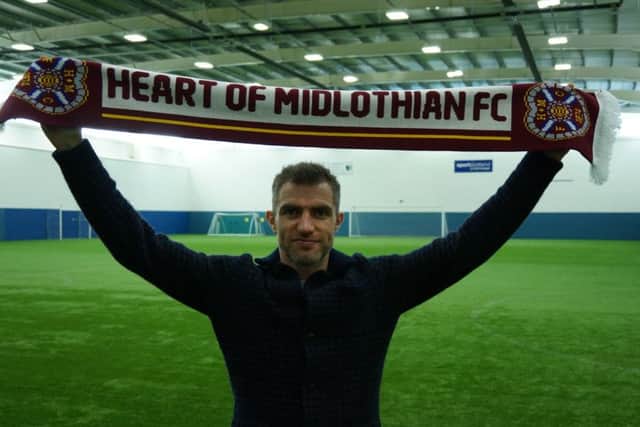 Northern Ireland defender Aaron Hughes has signed for Hearts until the end of the season