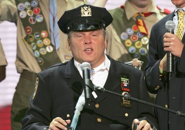 FILE- In this Aug. 30, 2004 file photo, New York Police Officer Steven McDonald recites the Pledge of Allegiance before the morning session of the Republican National Convention at Madison Square Garden in New York. On Tuesday, Jan. 10, 2017, officials said McDonald, who was paralyzed by a bullet and became an international voice for peace after he publicly forgave the gunman, died at the age of 59. (AP Photo/J. Scott Applewhite, File)