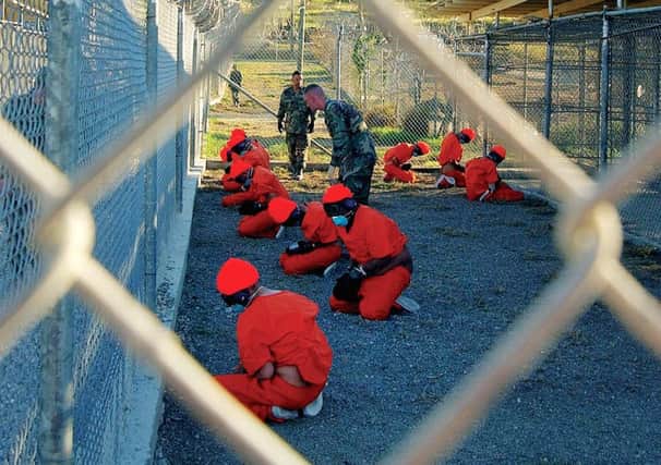 Shackled prisoners in a holding pen at Guantanamo detention centre