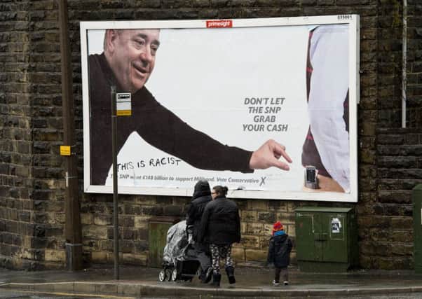 A family walk past a Conservative Party campaign poster in Colne, northwest England