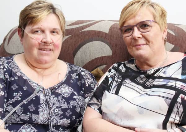 Joy Attwood(L) fighting cancer for a second time at home in Wawne, Yorshire with her sister Jennie. Picture: SWNS