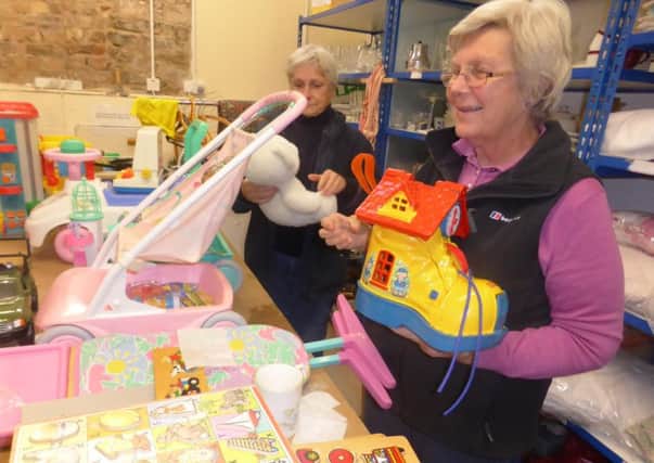 Volunteers working for Borders furniture reuse charity Home Basics sort out items at its Walkerburn depot for a Christmas toy sale. More people are volunterring to help care for people.