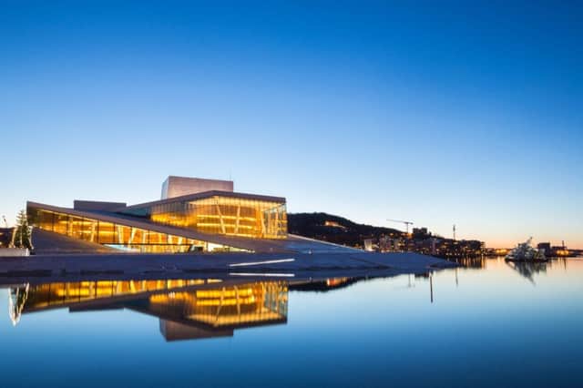 Oslo Opera House appears to rise from the fjord in the twilight