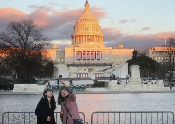 Tourists take a selfie in front of the western side of the US Capitol building which has been prepared for todays inauguration ceremony. Picture: Getty Images