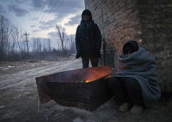 Migrants warm themselves by the fire outside of derelict brickyard in Subotica, Serbia. Homeless refugees face a desperate battle against freezing temperatures in the Balkans. Photograph: Srdjan Stevanovic/Getty