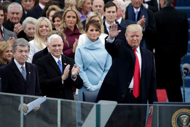 President Elect Donald Trump waves to spectators as Vice President Elect Mike Pence and Melania Trump look on. Picture: Getty