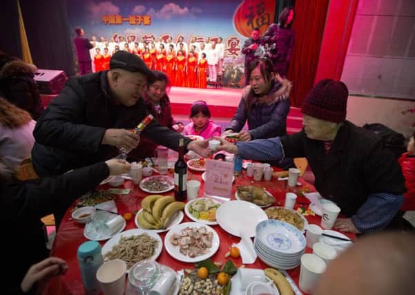 A man serves Chinese baijiu liquor during a 1,000 people New Year dumpling feast in Liuminying. Picture: AP
