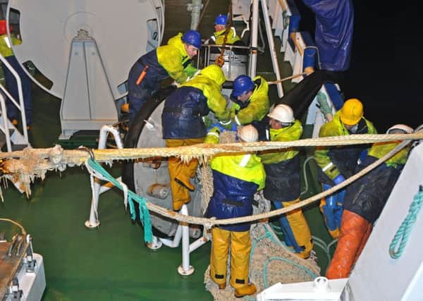 crewmen working on the deck whilst fishing for blue whiting