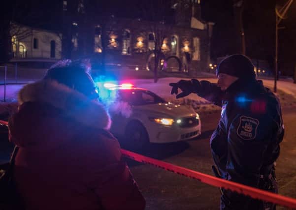 A Canadian police officer talks to a woman after a shooting in a mosque at the QuÃ©bec City Islamic cultural centre. Picture: AFP PHOTO/Alice Chiche