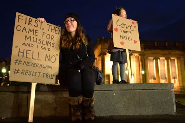 Demonstrators hold placards as they march from the Mound to the Scottish Parliament to protest against President Trump's Muslim travel ban. Picture: Getty Images