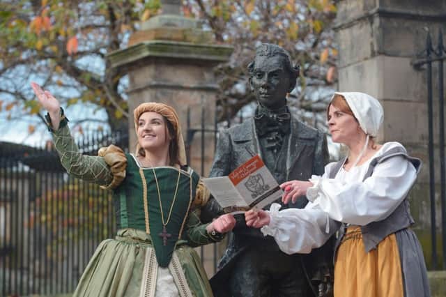 Nicola Wright and Hannah Broadley of Mercat Tours pose next to a statue of poet Robert Fergusson in Edinburgh's Canongate. The firm enjoyed a record 2016. Picture: Phil Wilkinson/JP Resell