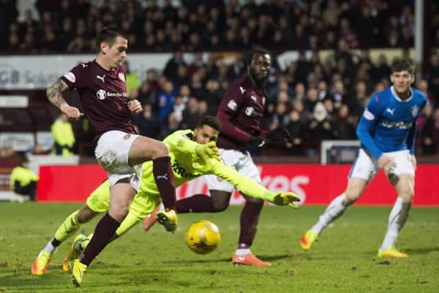 Jamie Walker slides into an empty net to put Hearts 4-1 up against Rangers. Picture: SNS