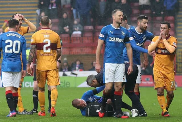 Scott McDonald, far right, is stunned after being shown a straight red card for a challenge on Kenny Miller. Picture: PA