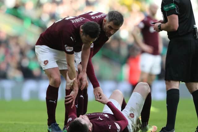 Hearts John Souttar is comforted by his team-mates after rupturing his Achilles tendon against Celtic. Pic: SNS
