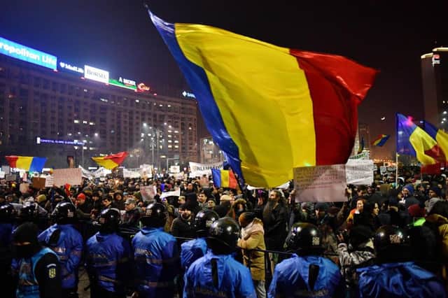 Romanian riot police stand guard as people demonstrate against controversial decrees to pardon corrupt politicians. Picture; getty