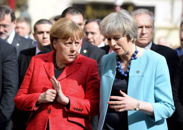 Germany's Chancellor Angela Merkel (L) speaks with Prime Minister Theresa May on their way for a group picture during a European Union summit  in Valletta, Malta. Picture: Getty Images