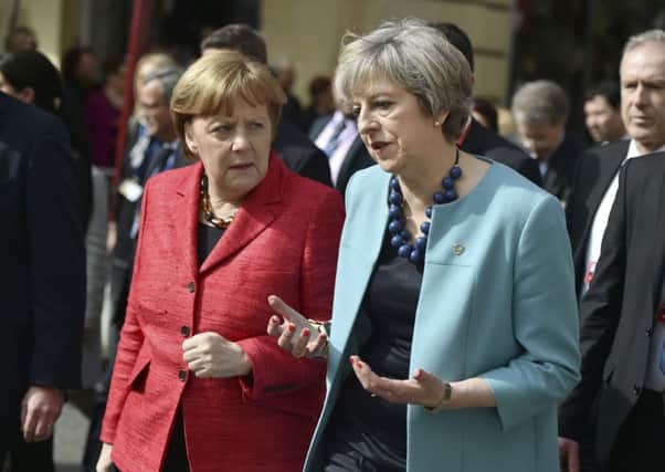 Theresa May speaks with German Chancellor Angela Merkel at an EU summit in Valletta. Picture: AP