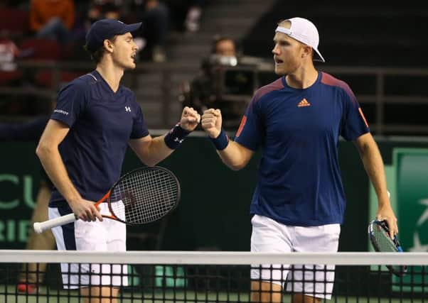 Jamie Murray, left, and Dom Inglot fist-bump after winning a set point against Vasek Pospisil and Daniel Nestor. Photograph: Andre Ringuette/Getty