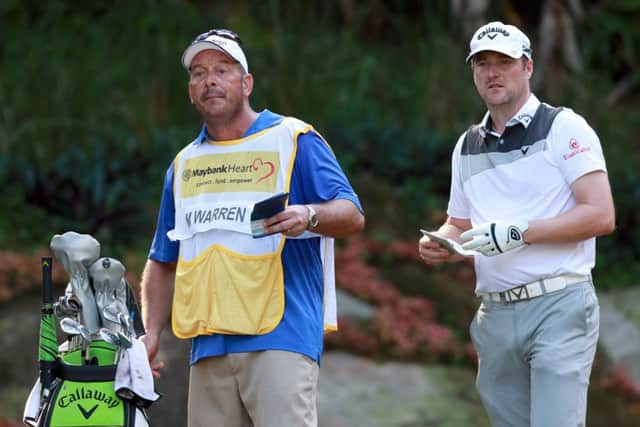 Marc Warren ponders a tee shot with his caddie Ken Herring en route to a nine-under-par opening round in the Maybank Championship. Picture: Getty Images