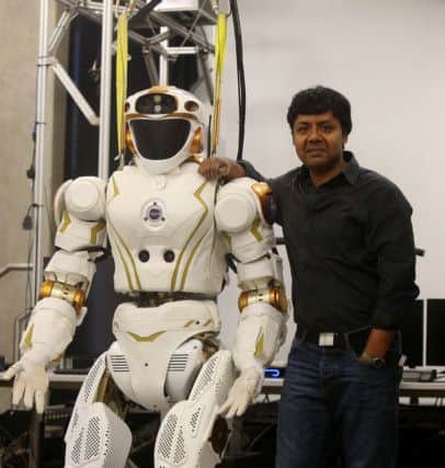 Prof Sethu Vijayakumar of Edinburgh University's Robotics dpeartment with robot Valkyrie. Picture: SWNS