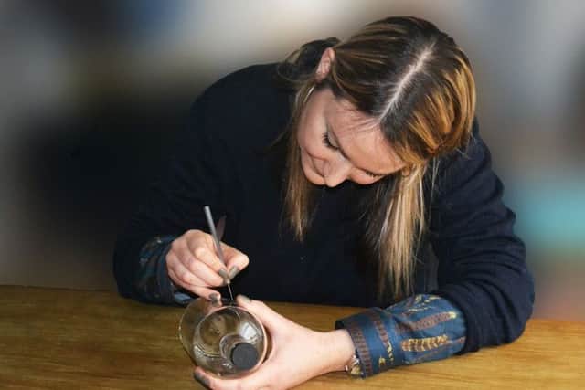 Glassware designer Lydia Macdonald hand-etches one of NB Gin's bottles. Picture: Contributed