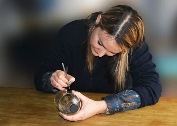 Glassware designer Lydia Macdonald hand-etches one of NB Gin's bottles. Picture: Contributed