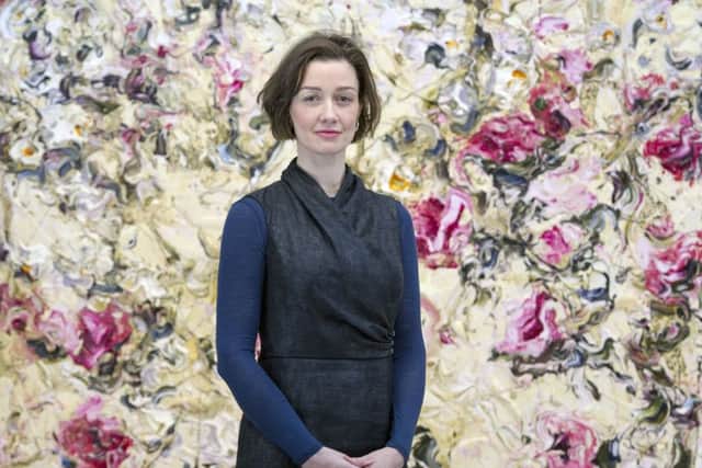 Christina Jansen stands in front of a painting by Geoff Uglow, whose works are on display at the gallery. Picture: Ian Rutherford