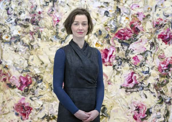 Christina Jansen stands in front of a painting by Geoff Uglow, whose works are on display at the gallery. Picture: Ian Rutherford
