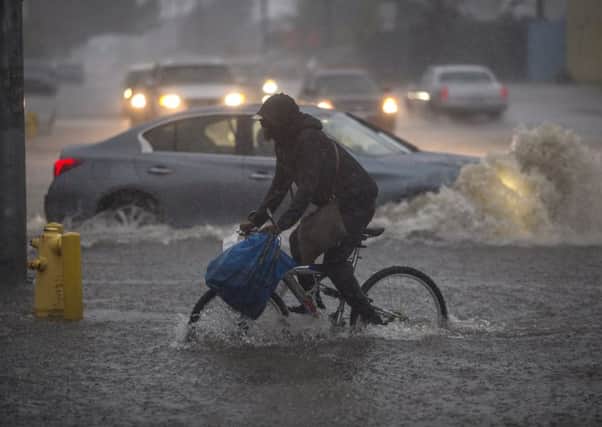 Firefighters rescue a woman after her car was caught in flooding in Sun Valley, California, on Friday. Picture: Getty