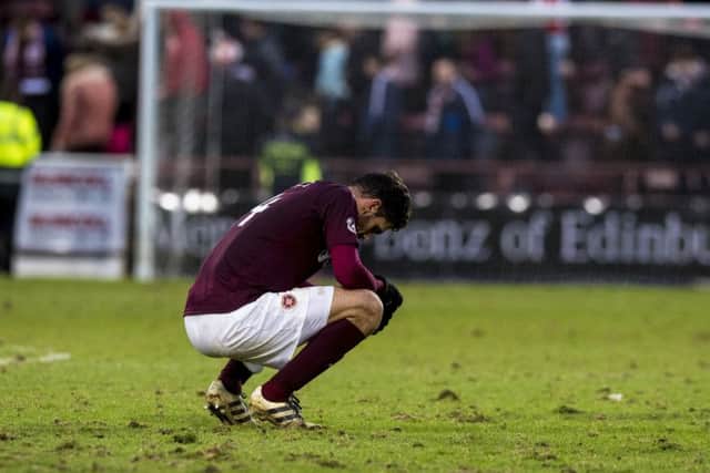 Alexandros Tziolos cuts a dejected figure on a badly cut-up Tynecastle pitch on Saturday. Picture: SNS.