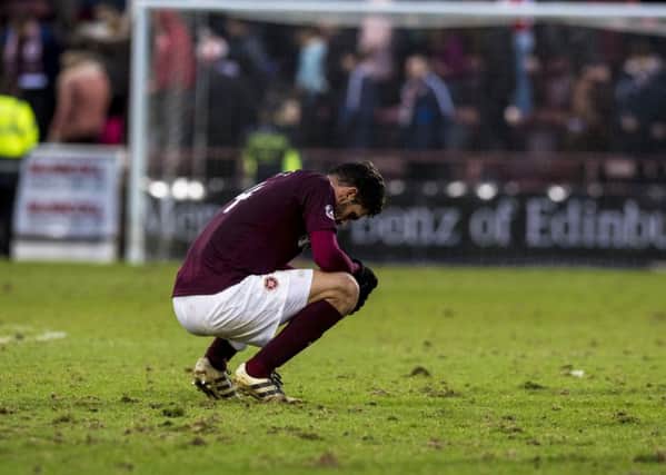 Alexandros Tziolos cuts a dejected figure on a badly cut-up Tynecastle pitch on Saturday. Picture: SNS.