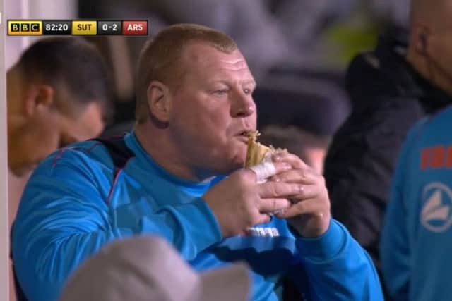 Sutton's reserve goalkeeper Wayne Shaw eating a pie on the touchline. Picture: BBC/PA