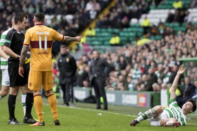 Celtic's Kieran Tierney (right) on the deck after the challenge by Ryan Bowman. Picture: SNS